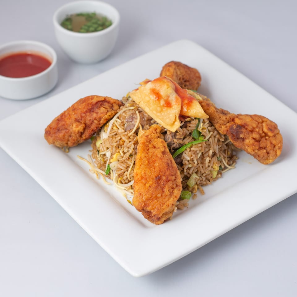 Everything Noodles' fried rice with crispy chicken wings and wontons, served with dipping sauces.